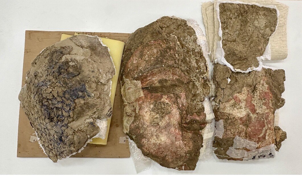 Four pieces of an artifact lay together on a table.